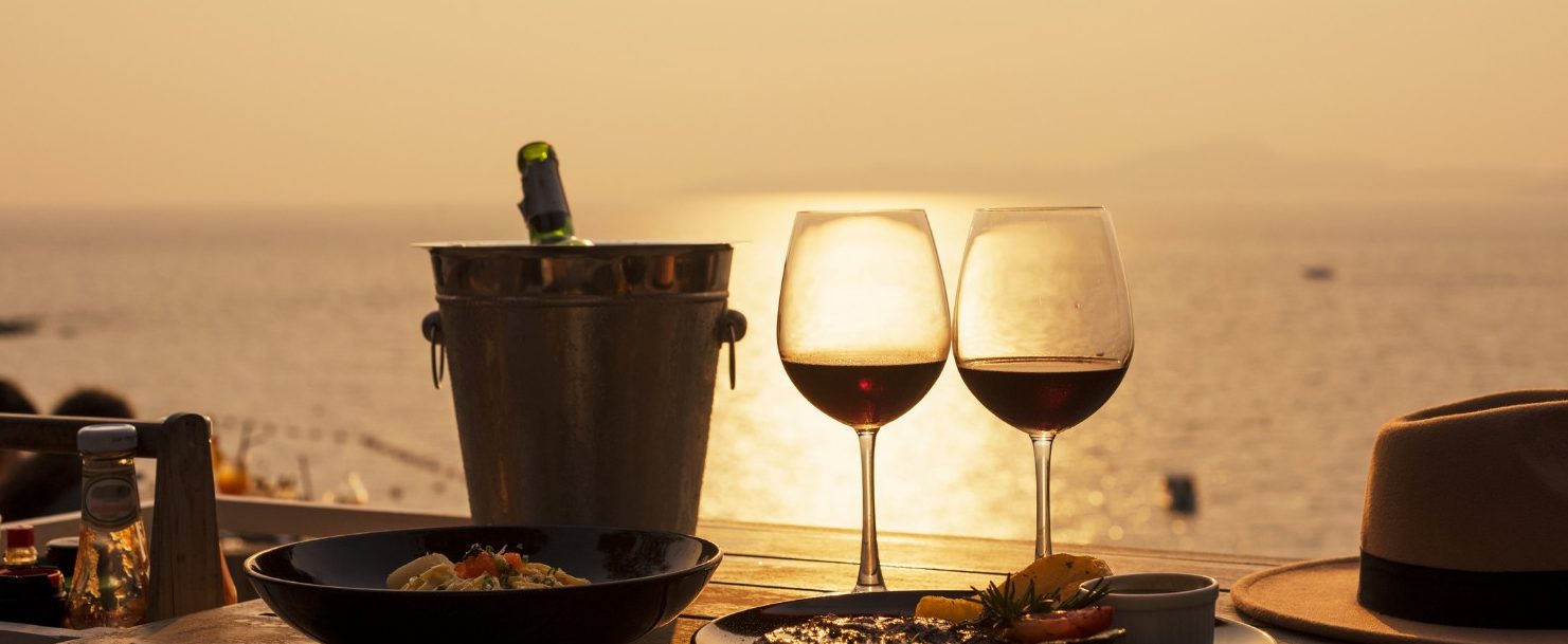 View of wine glasses in front of a sunset showing the best of Sandestin dining