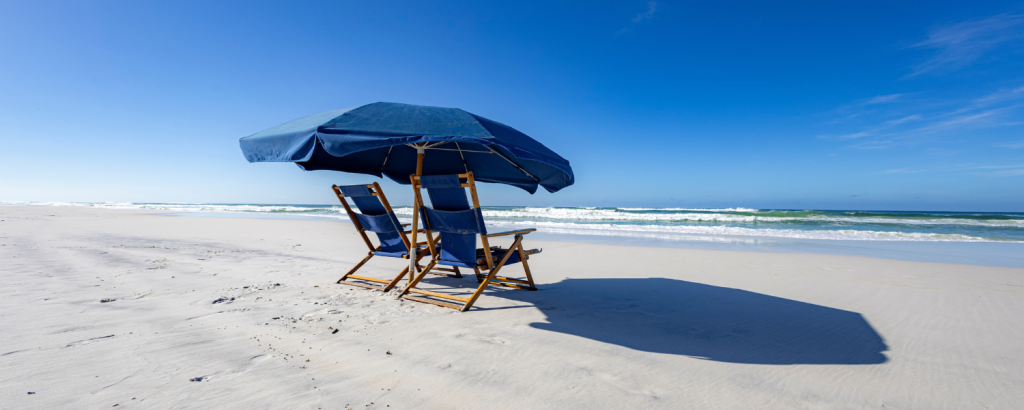 two chairs and umbrella on a beach