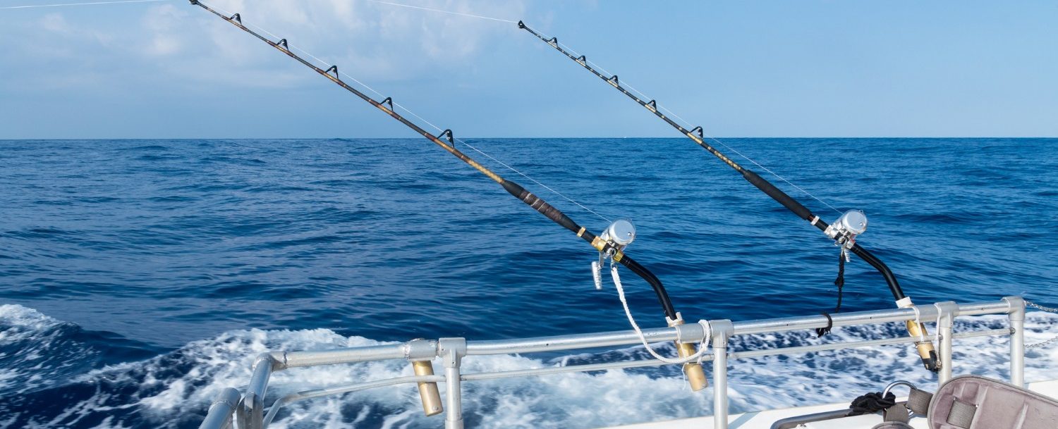 Deep sea fishing in Sandestin, FL, in the ocean on a sunny blue sky day with fluffy clouds.