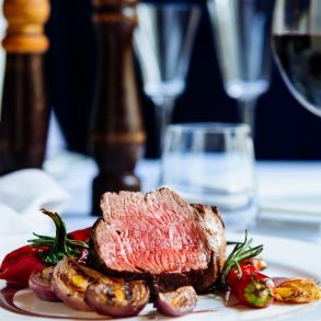 Beef steak with grilled vegetables served on white plate | Best Restaurants in Sandestin