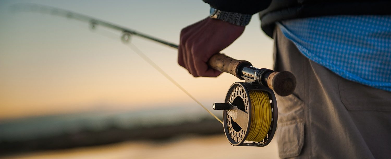 Close up of a man holding fishing rod at sunset | 30A fishing