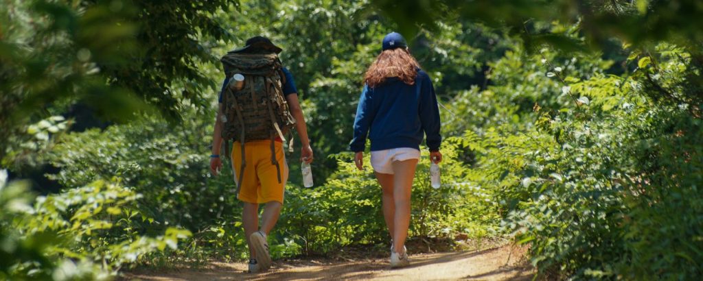 two people walking on a trail