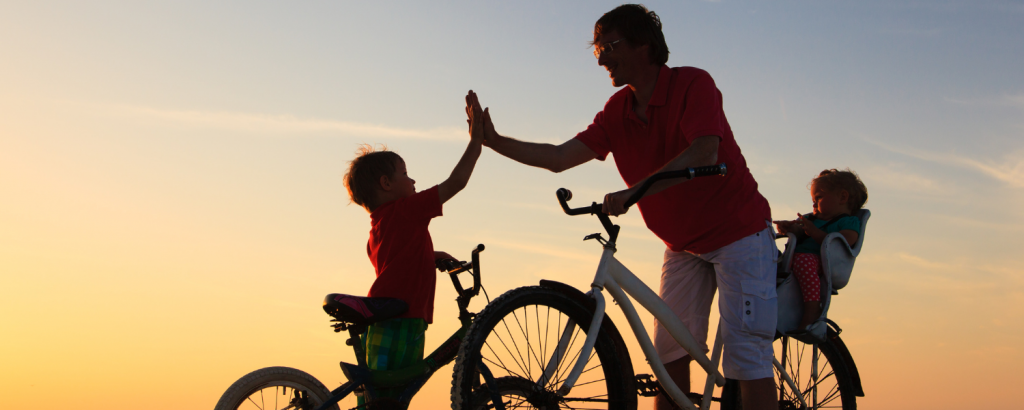 family riding bikes at sunset
