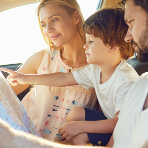 family in car looking at map