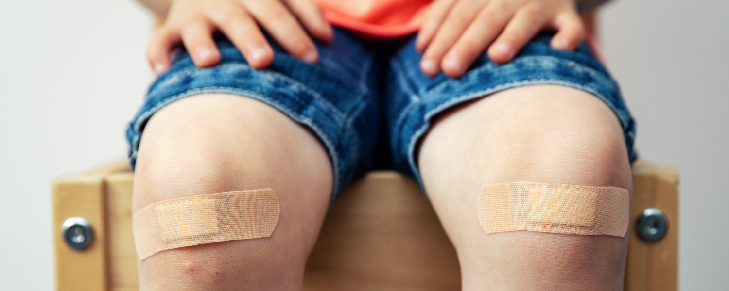 child with bandages on knees