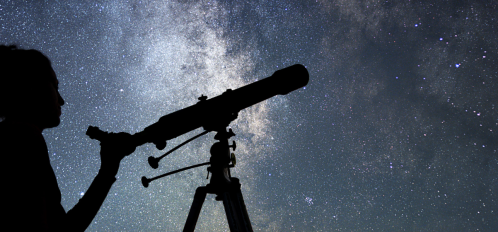 woman with telescope against night sky