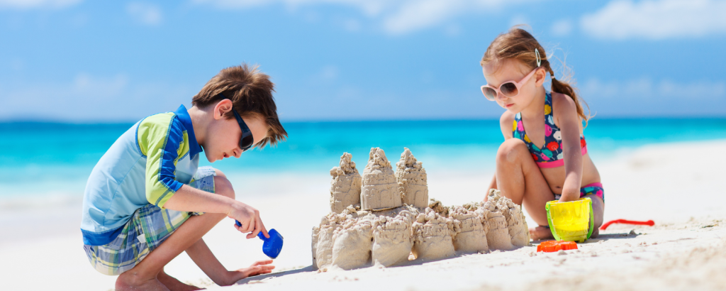 two children building sandcastle on beach