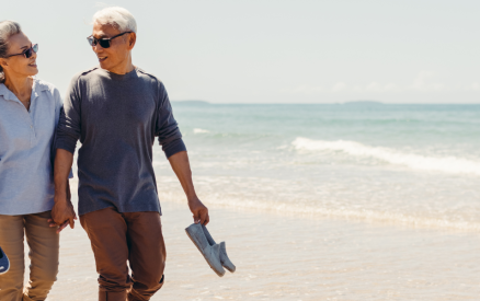 couple walking on beach in long pants