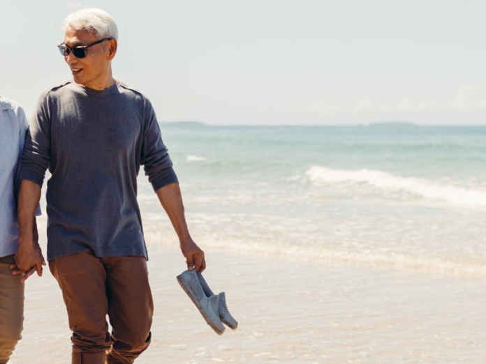 couple walking on beach in long pants