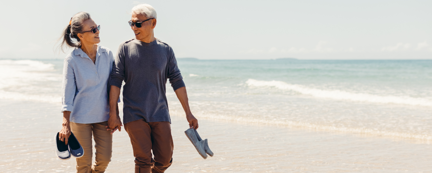 couple walking on beach in long pants