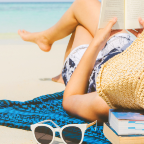 woman reading book on beach