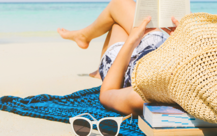 woman reading book on beach