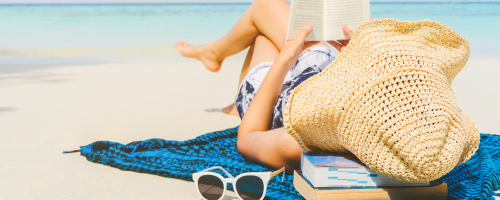 woman reading book on beach