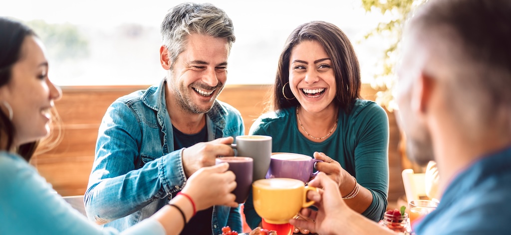 People group toasting a latte at the coffee bar rooftop.