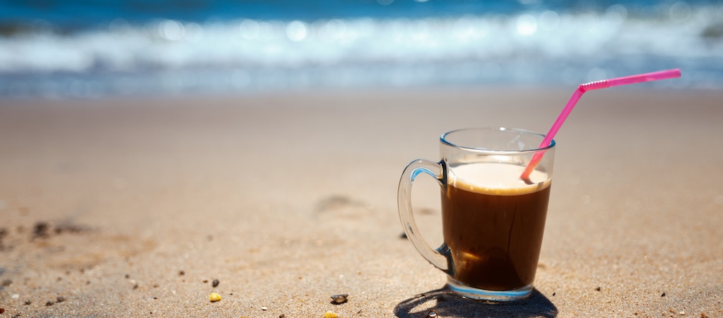 Iced coffee on a beach.