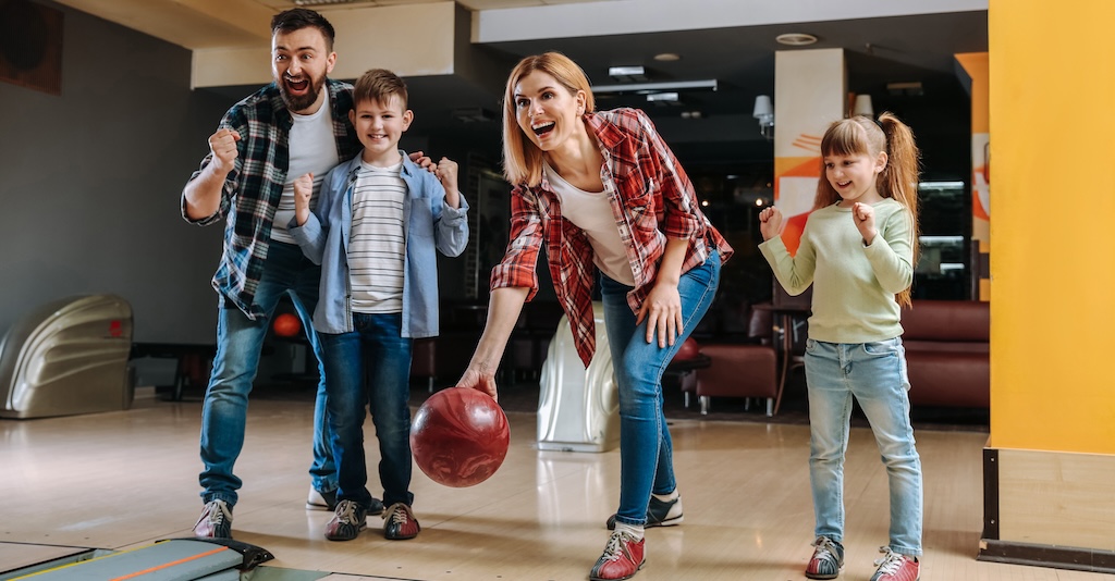 Family playing bowling in club