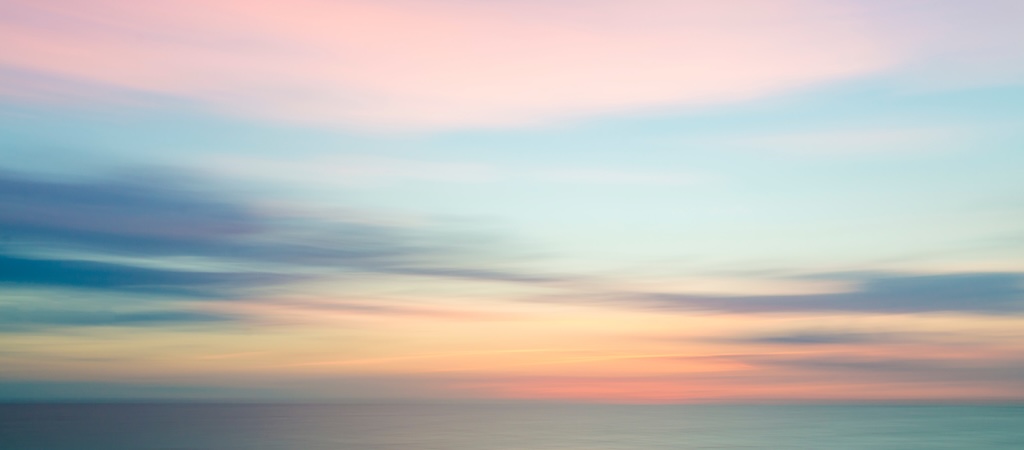 Abstract sunset sky and ocean nature background with blurred panning motion.